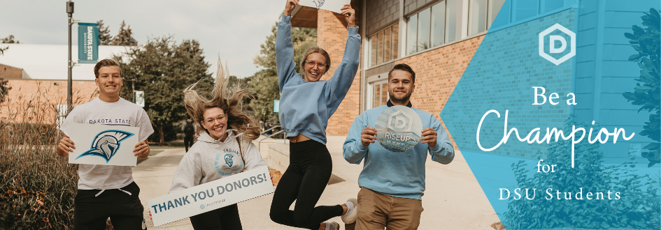 four students holding signs jumping